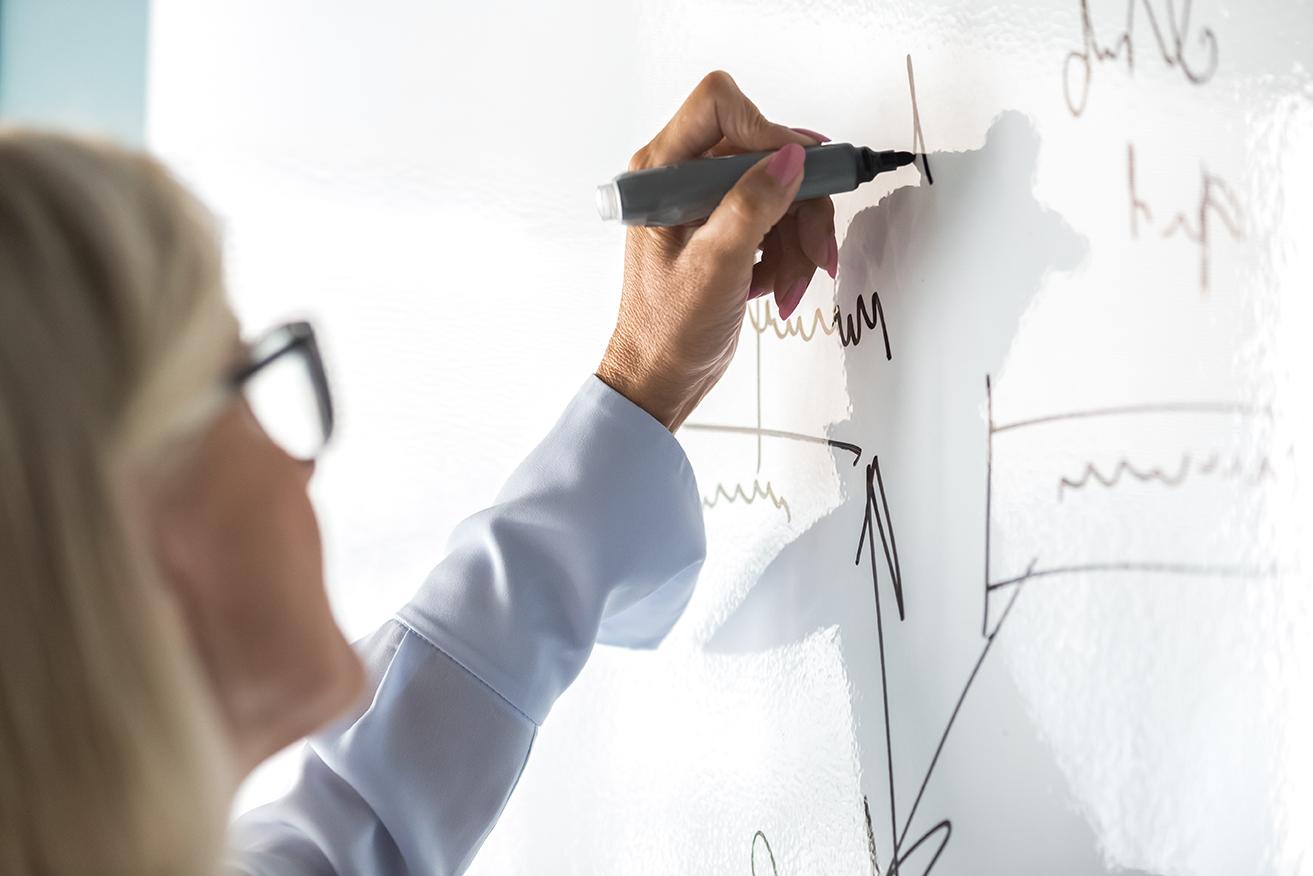 Person writing on a white board