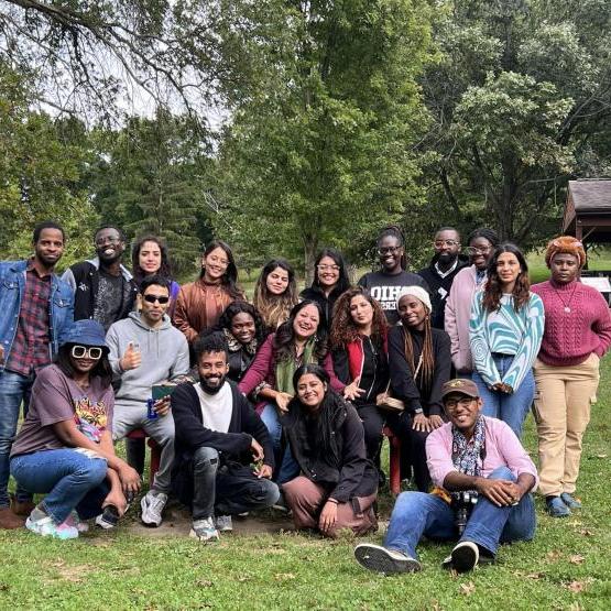 A group of Communication and Development Studies students pose, smiling, in a park